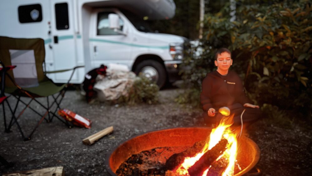 Haciendo barbacoa nocturna en un campground público de Canadá en autocaravana