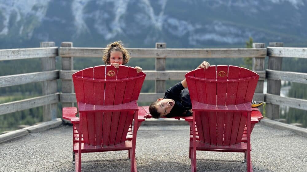 En las típicas sillas rojas de los Parques de Canadá en el mirador a los Hoodos de Banff