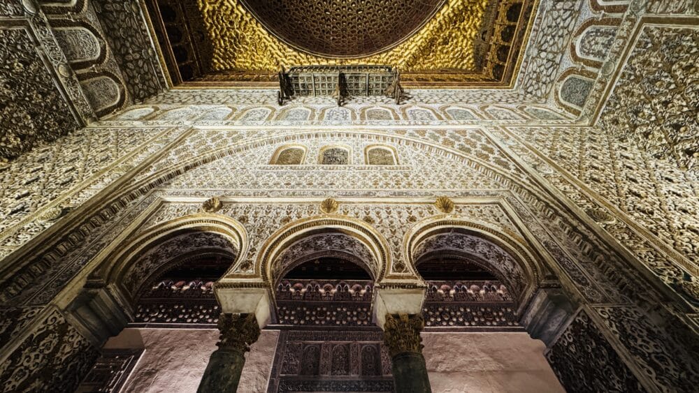 Estancia interior del Palacia del Alcázar Real de Sevilla de estilo mozárabe preciosa con detalles de yeso blanco y oro y arcadas y columnas de estilo árabe